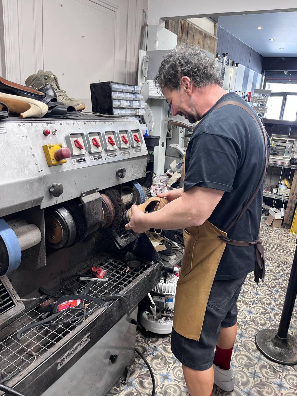 L'artisan cordonnier en plein travail à son établi